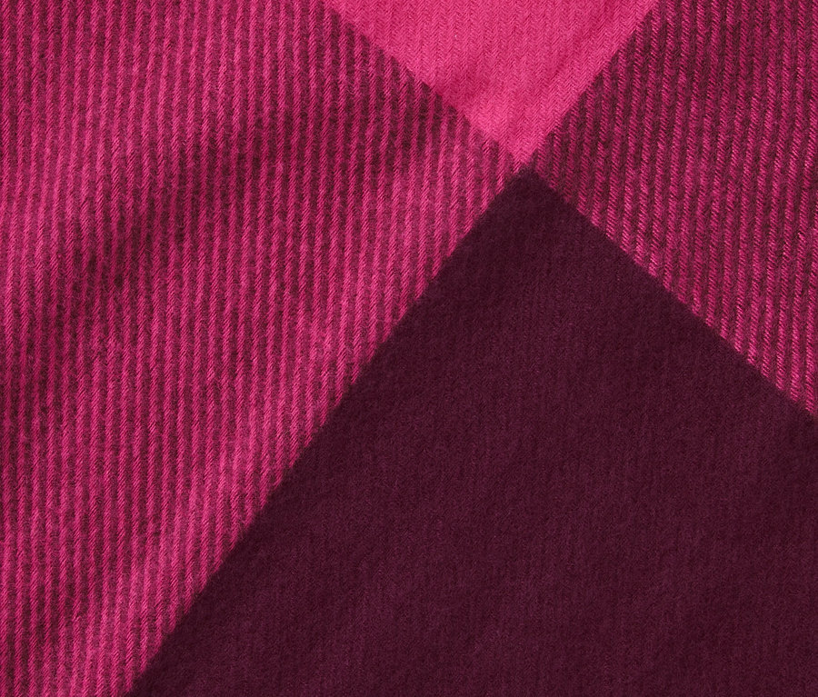 Nahaufnahme eines pink-weinroten Schals mit Fransen.