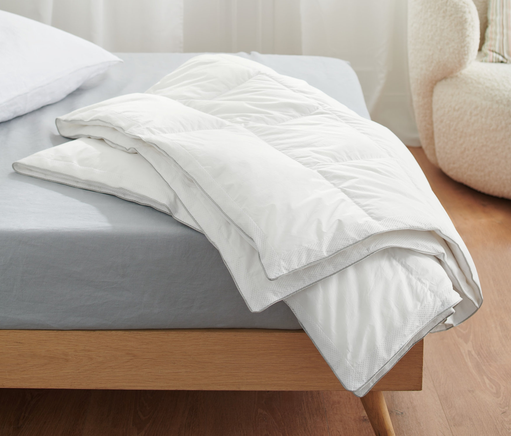 Auf einem Bett liegen drei Temprakon Zone Ganzjahresdecken in Normalgröße und eine in Übergröße.