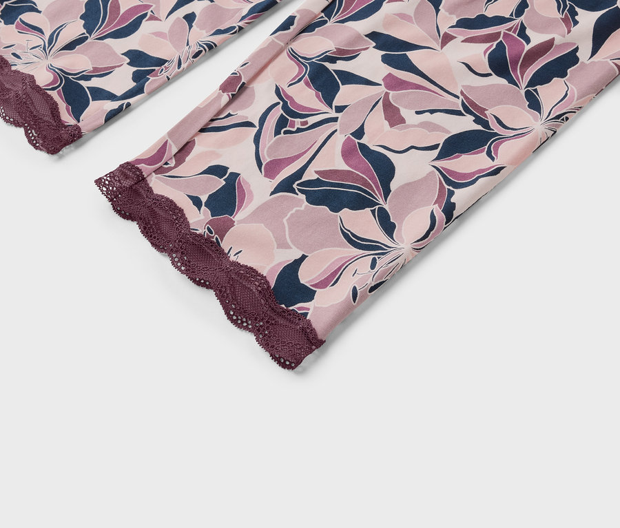 Detail einer Damenhose mit Blumenmuster und Spitze.