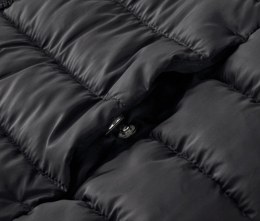 Detailaufnahme einer schwarzen Steppjacke mit Druckknopf.