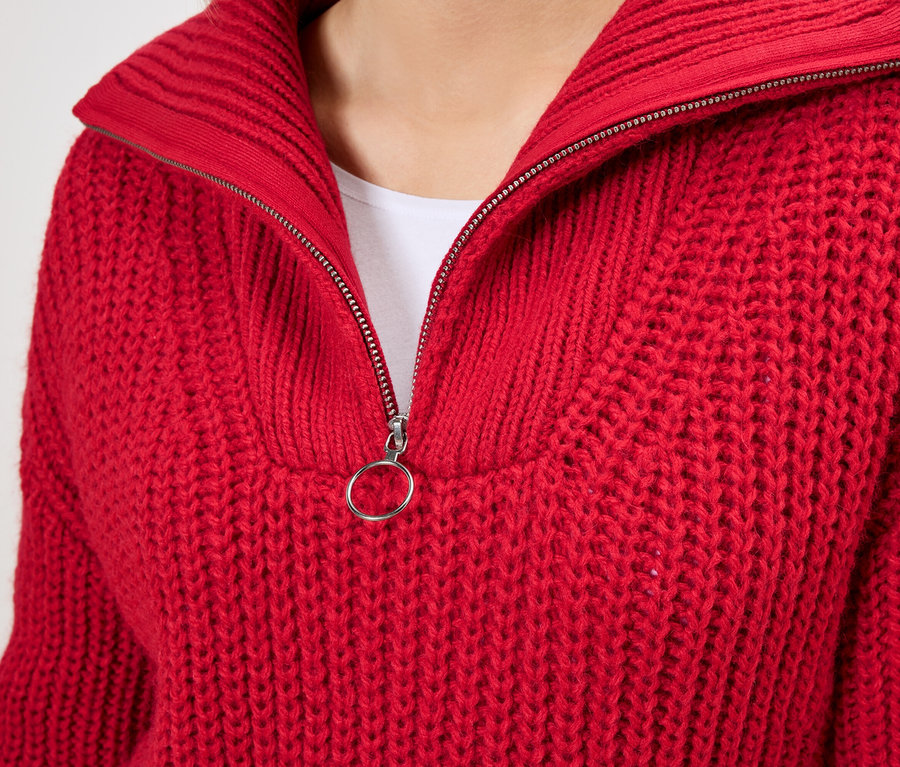 Detailaufnahme eines roten Strickpullovers mit Reißverschlusskragen.