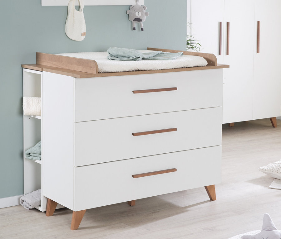 Kinderzimmer mit weißer Wickelkommode »Ole« mit drei Schubladen und Holzplatte, weißes Regal mit Deko und weißem Schrank.