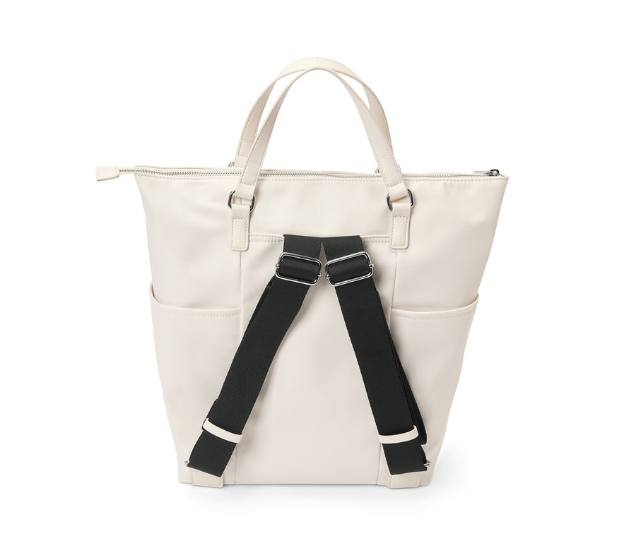 Ein cremefarbener Canvas-Rucksack mit schwarzen Trägern.