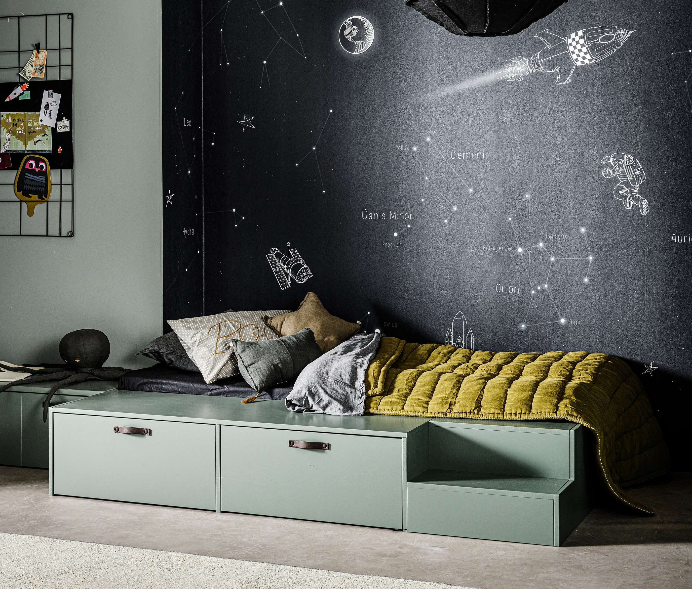 Ein grünes vtwonen Bett »Stage«, kiefer soap mit Matratze und Kissen steht vor einer Wand mit Weltraumzeichnungen.