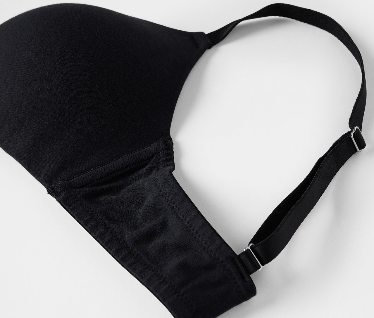 Detailansicht eines schwarzen BHs auf weißem Hintergrund.