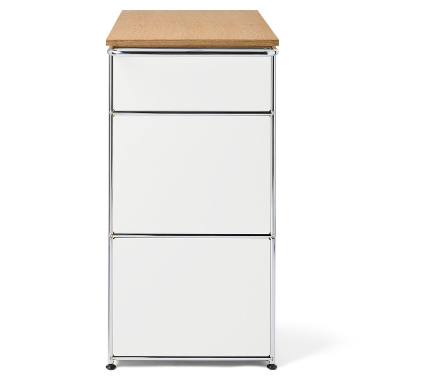 Schrank mit drei weißen Schubladen und heller Holzplatte.