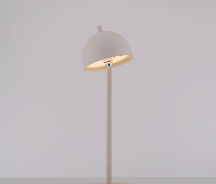 Beige Lampe mit rundem Schirm auf einem Sockel.
