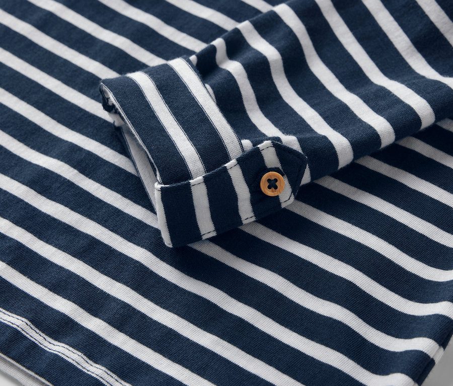 Detailaufnahme eines blau-weiß gestreiften Kinder-Langarmshirts mit Knopf.