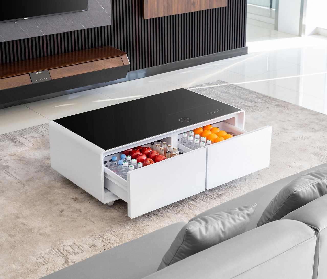 Weißer Caso Sound & Cool Tisch mit Schubladen gefüllt mit Getränken und Früchten steht im Wohnzimmer.