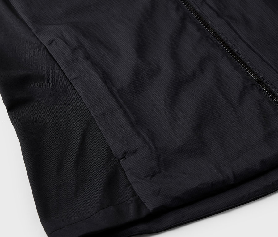 Detailansicht einer schwarzen Jacke mit Reißverschluss und Seitentasche.