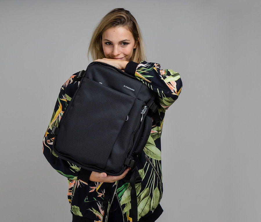 Frau hält einen schwarzen Tucano TUGO Kabinenrucksack mit Laptopfach.