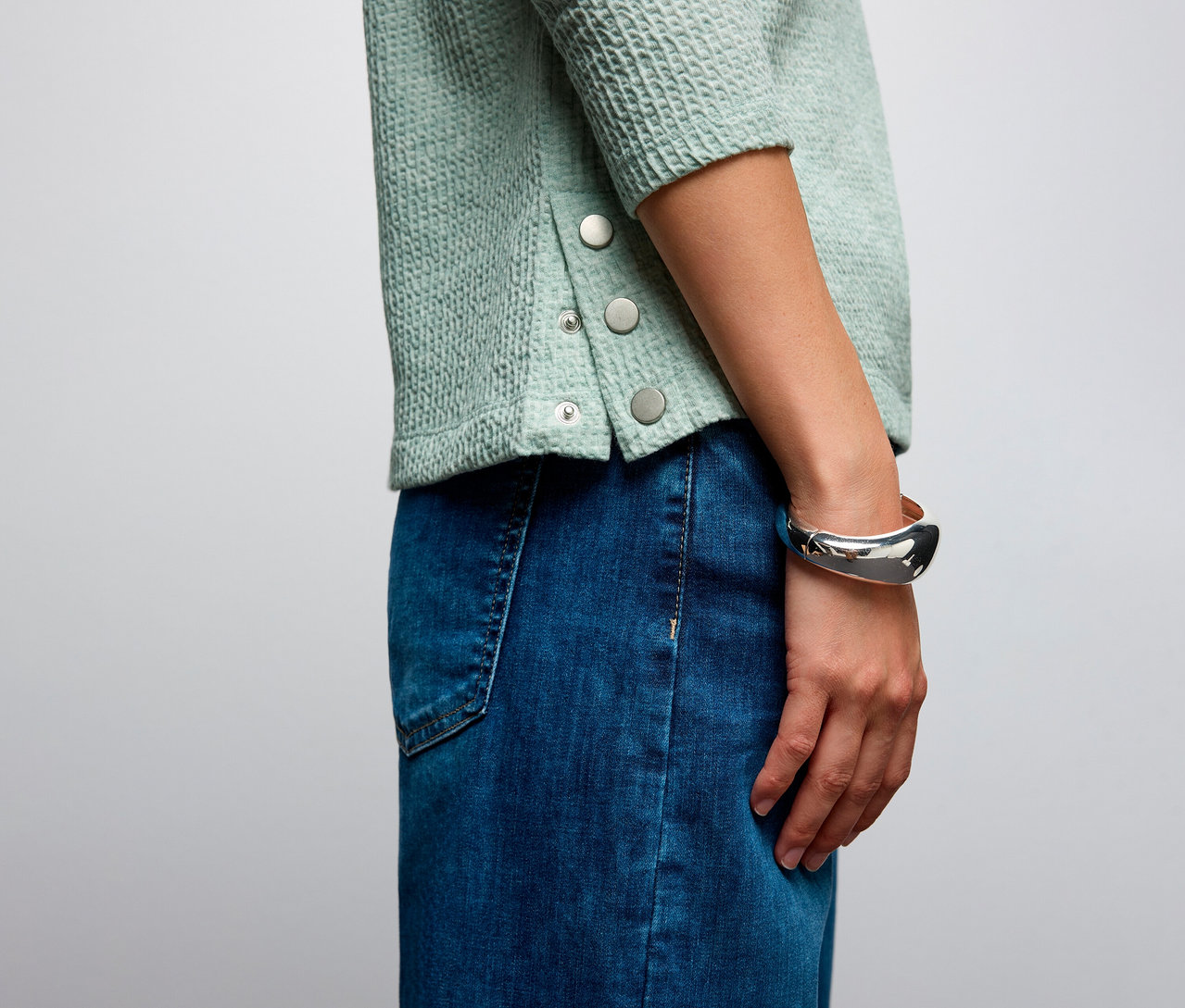 Nahaufnahme einer Frau, die ein Street One Shirt mit Struktur und einen Jeansrock trägt.