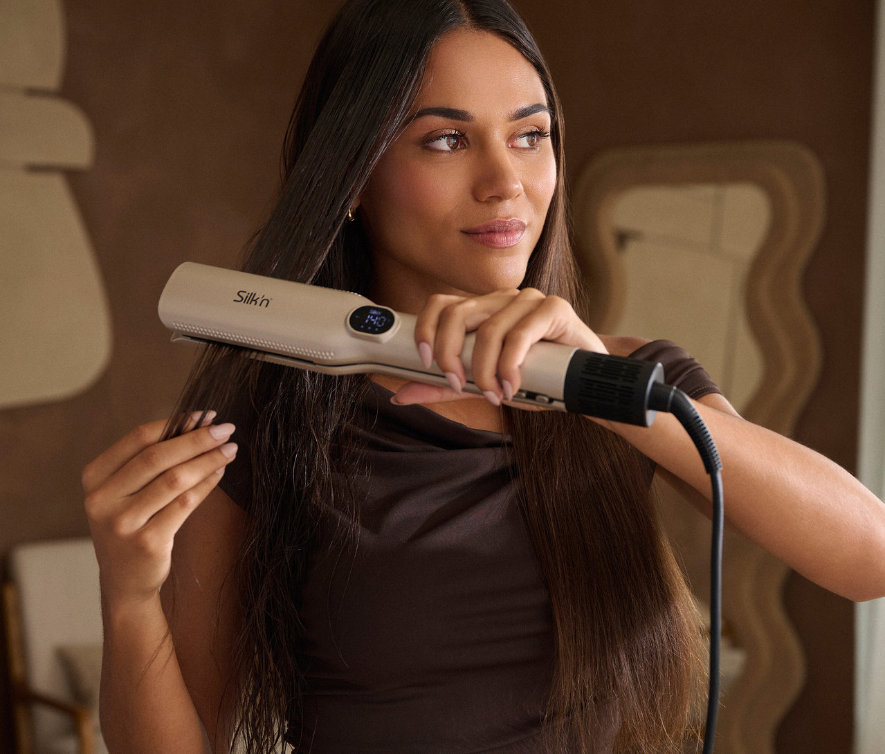 Frau glättet ihr Haar mit Silk'n »Trinity Glätten, Trocknen, Stylen«
