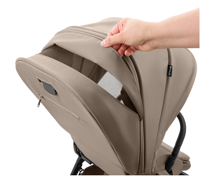 Eine Hand öffnet das Verdeck eines hellbraunen Kinderwagens und gibt ein Netzfenster frei.