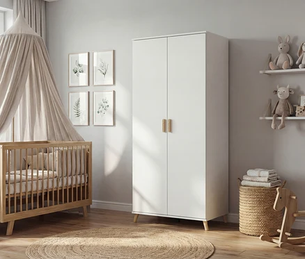 Kinderzimmer mit Gitterbett unter Baldachin, weißem Schrank mit Holzgriffen, rundem Teppich und Deko.