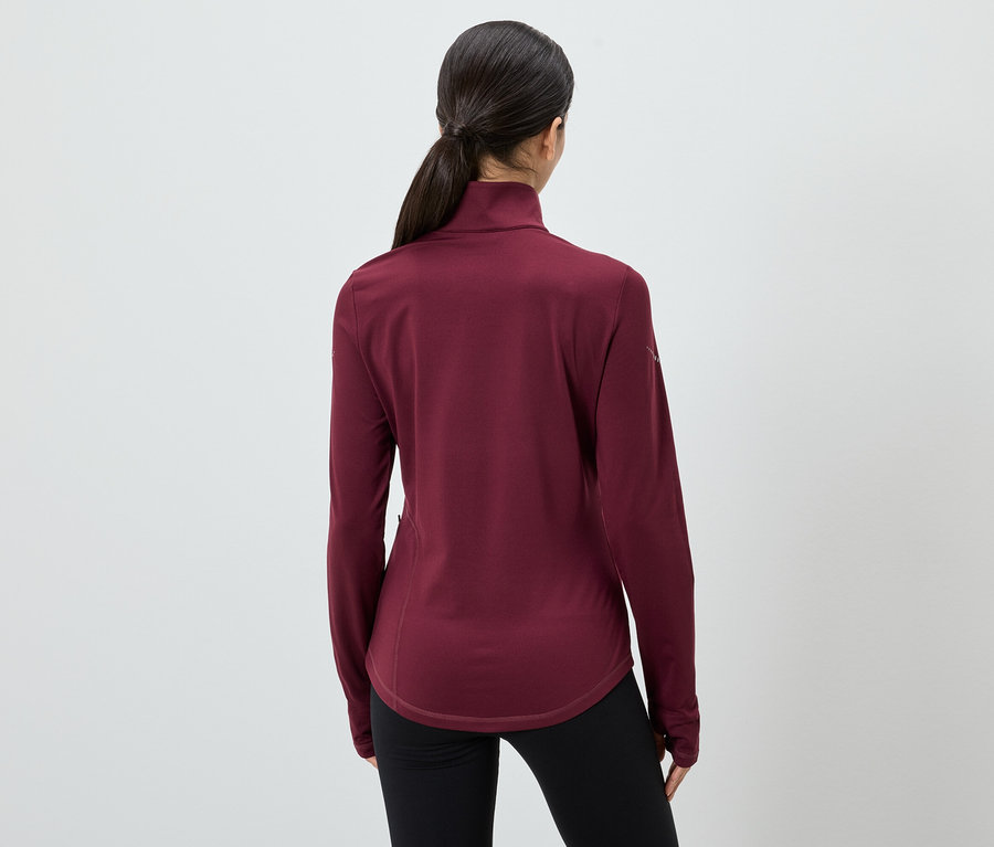 Rückansicht einer Frau mit Pferdeschwanz, die ein weinrotes Langarmshirt und schwarze Leggings trägt.