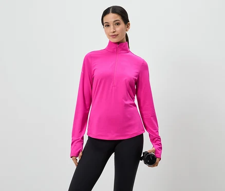 Frau in pinkem Langarmshirt mit Reißverschluss und schwarzen Leggings, hält eine Wasserflasche vor einem weißen Hintergrund.