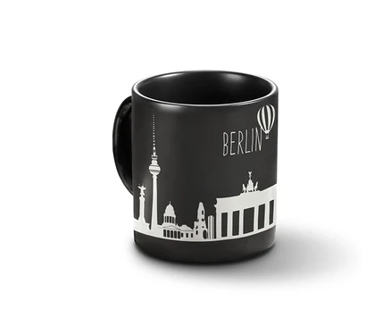 Schwarzer Kaffeebecher Berlin mit weißem Aufdruck Berliner Sehenswürdigkeiten.