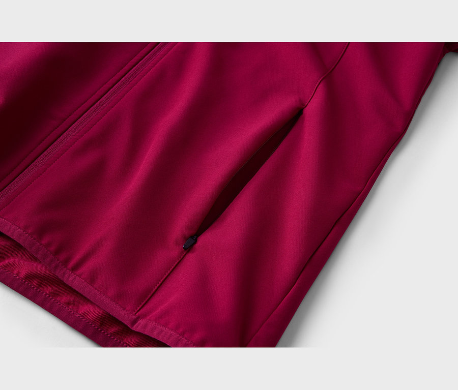 Nahaufnahme einer dunkelroten Jacke mit einem diagonalen Reißverschluss auf der linken Seite und einer diagonalen Tasche mit Reißverschluss auf der rechten Seite.