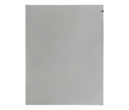 Graue Tischdecke in Übergröße aus der SCHÖNER WOHNEN-Kollektion mit kleinem schwarzem Etikett oben rechts.