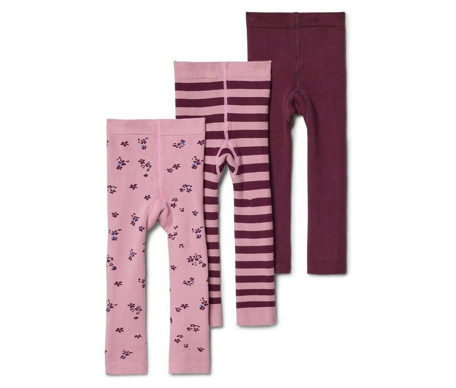 Drei Kinderleggings liegen übereinander: eine hellrosa mit Blumenmuster, eine hellrosa gestreift und eine bordeauxrote.