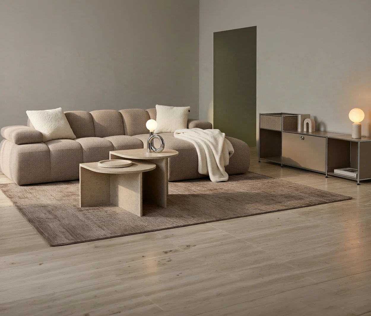 Ein Wohnzimmer mit beigefarbenem Sofa. Davor stehen 2 halbrunde Couchtische "Leo", einer mit Lampe und Deko-Objekt, der andere mit einer Schale. Rechts ein Sideboard mit Lampe.
