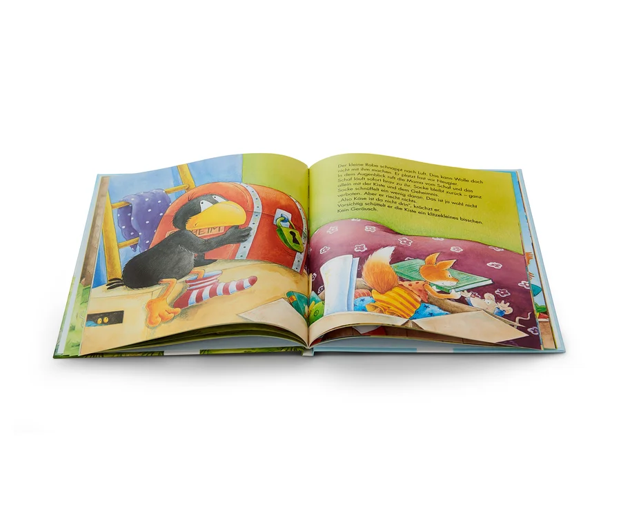 Illustration aus dem Buch: Der kleine Rabe Socke sitzt an einer Truhe, im Hintergrund sind ein Schaf und ein Fuchs zu sehen.