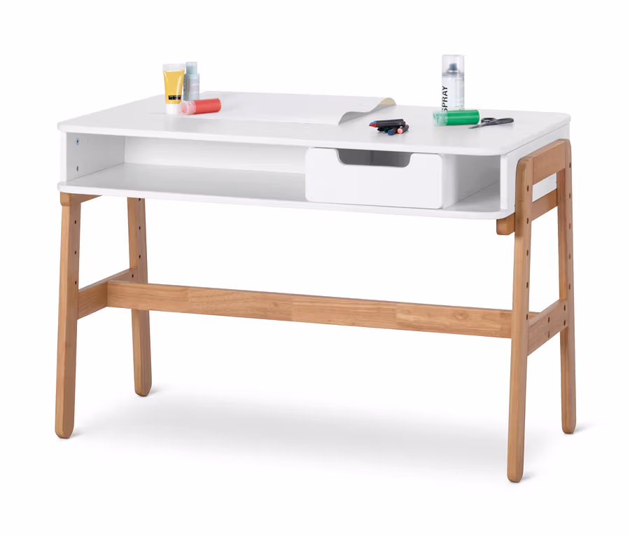Ein weißer und heller Holztisch mit Farben, Markern und Papier darauf.