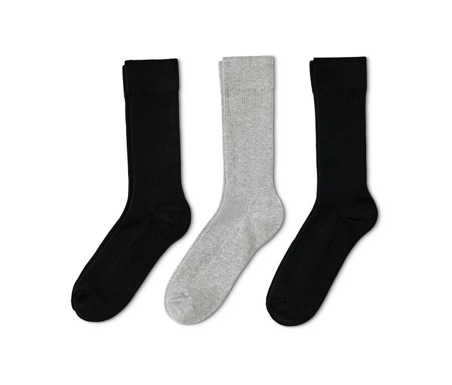 Drei Paar Socken: zwei schwarze und ein graues.