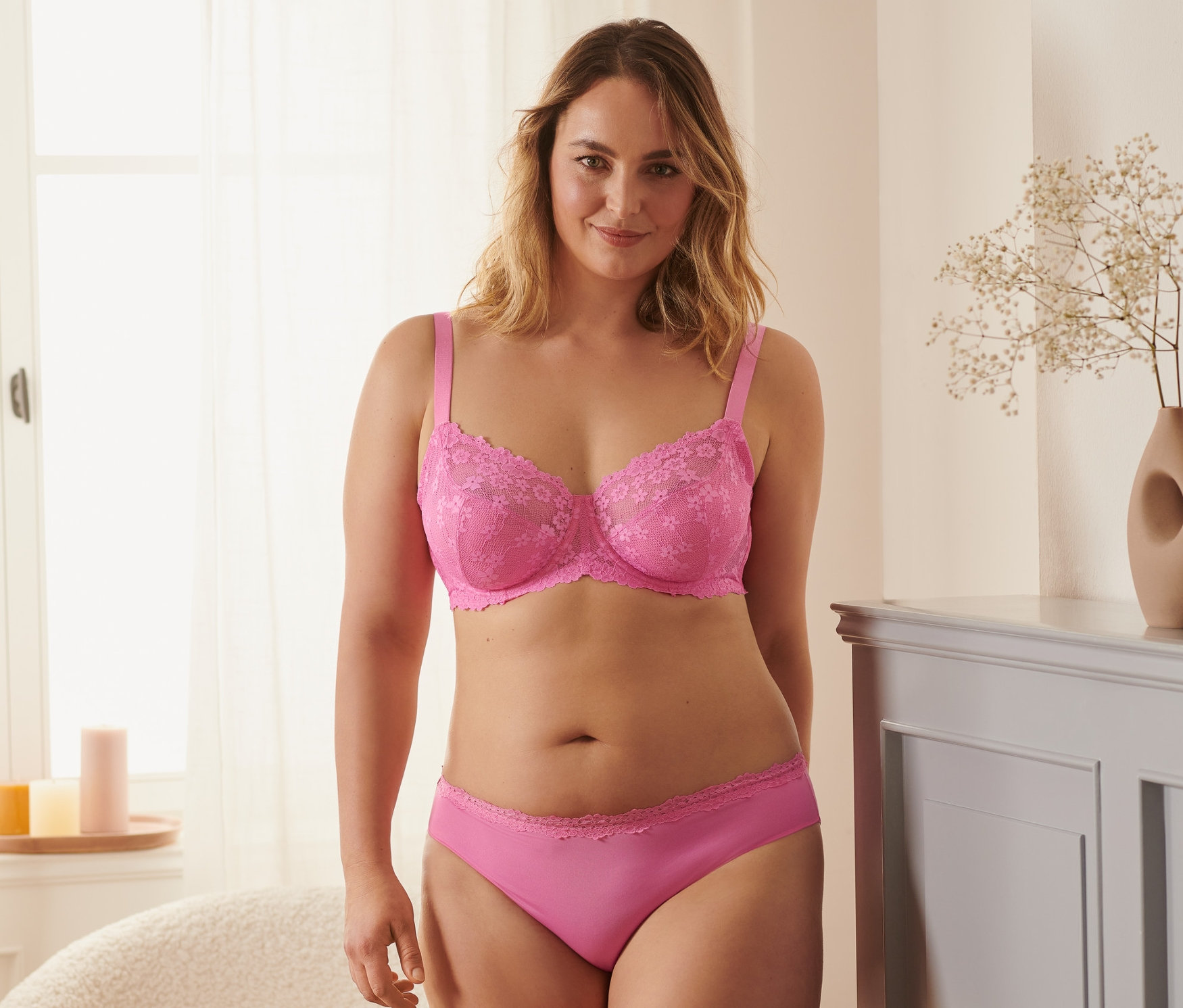 Frau trägt einen Bügel-BH und Höschen in Pink.