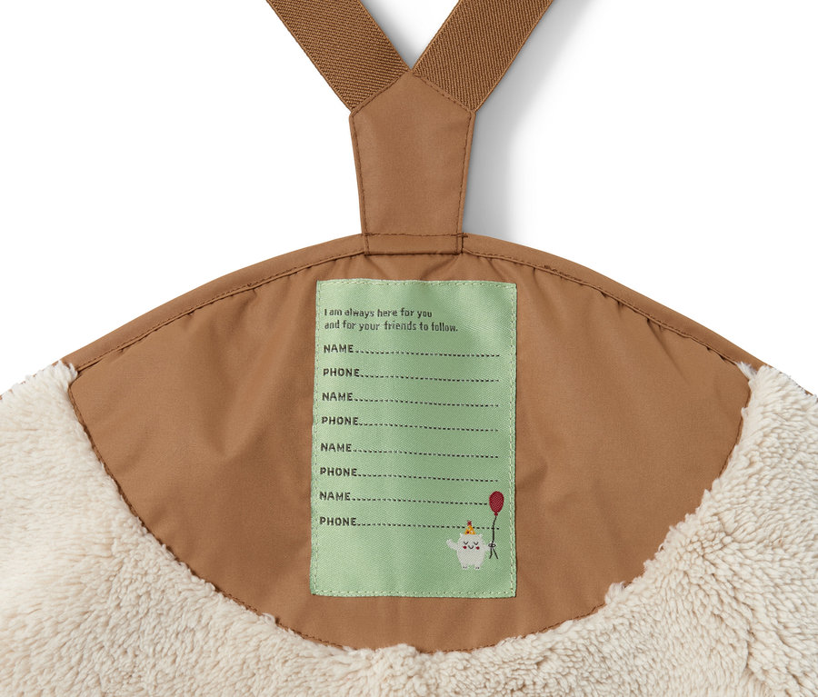 Detail einer Regenhose in Braun mit beigem Fellfutter und Namensschild.