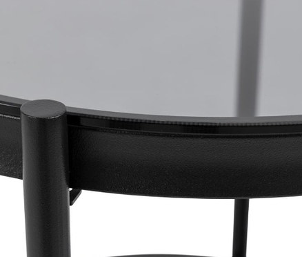 Detailansicht eines runden Glas-Beistelltisches mit schwarzem Rahmen.