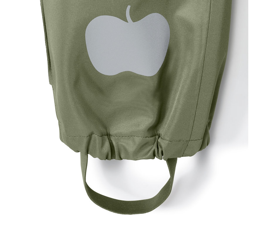 Detail eines Hosenbeins vom Regeneinteiler aus recyceltem Material mit reflektierendem Apfellogo und Stiefelriemen.