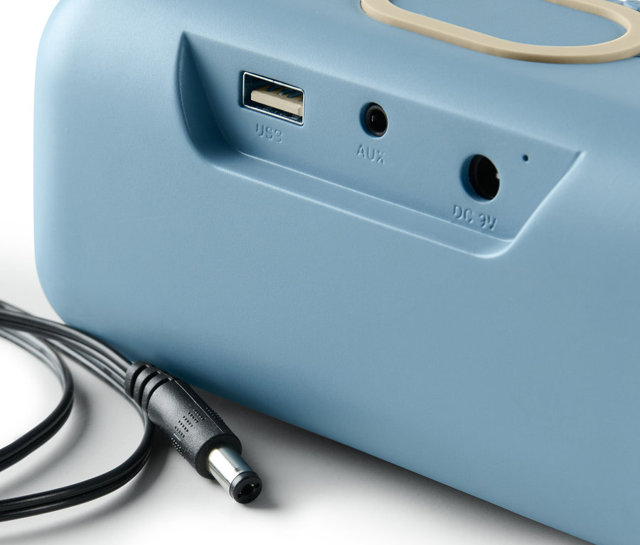 Detailansicht eines blauen Lautsprechers mit Qi-Charging und Kabel.