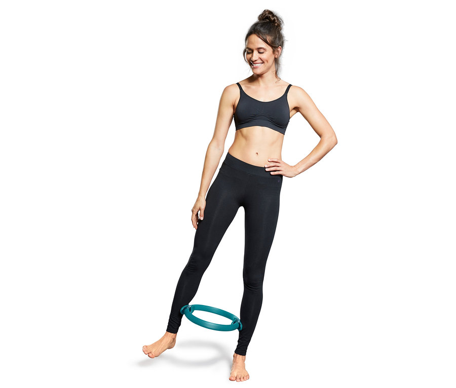 Frau trainiert mit Pilatesring.