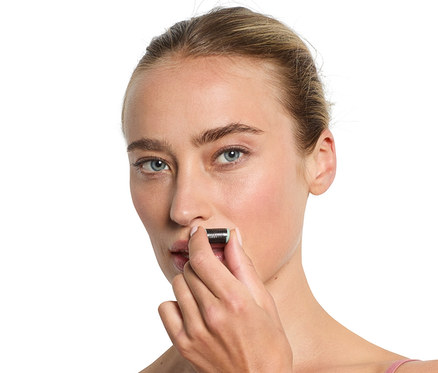 Frau verwendet Mini-Gesichtsepilierer.