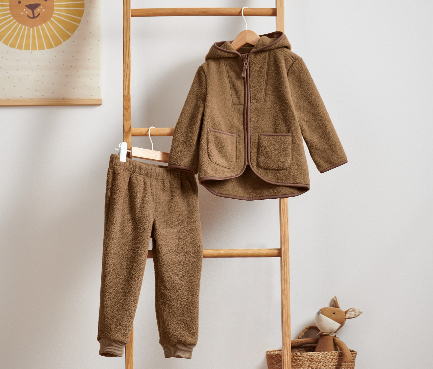 Ein Teddyfleece-Kombi hängt auf einer Holzleiter.
