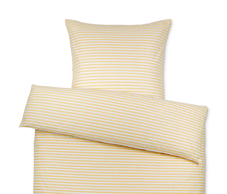 Draufsicht auf ein Seersucker-Bettwäsche-Set mit gelben und weißen Streifen, bestehend aus einem Kissen- und einem Bettbezug.