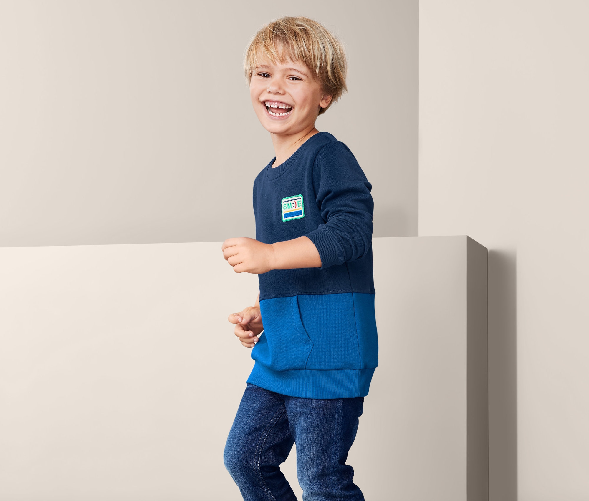 Ein Junge trägt ein blaues Sweatshirt.