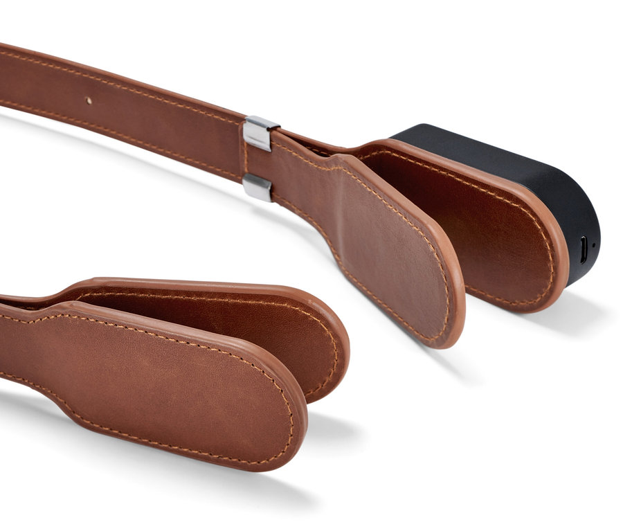 Detail einer Leselampe mit magnetischem Clip-System, braunes Lederband und schwarze Lampe.