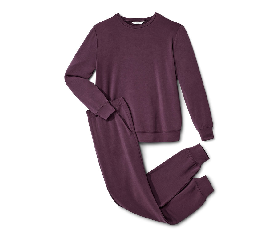 Ein lilafarbener Hausanzug liegt auf einem weißen Hintergrund.