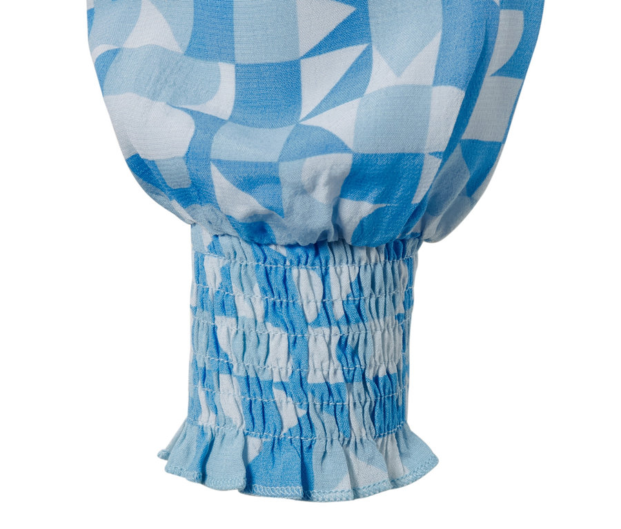Detail einer bedruckten Bluse mit blau-weißem geometrischem Muster und elastischem Abschluss.