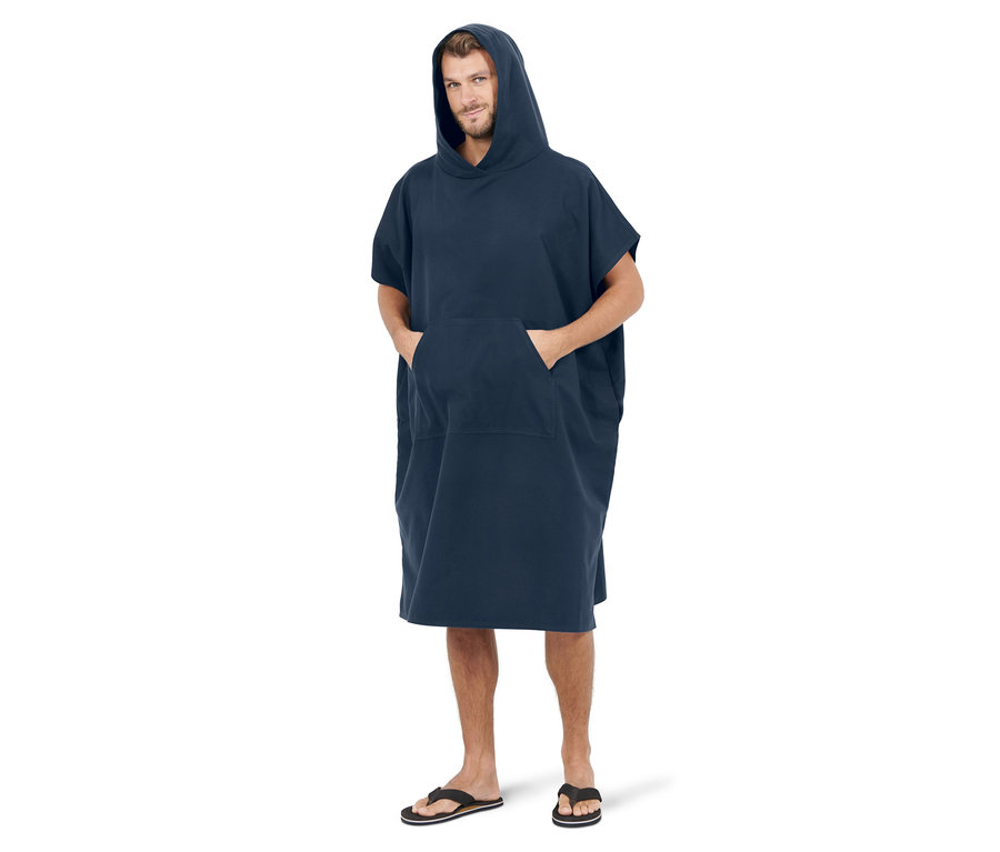 Mann steht und trägt einen blauen Umzieh-Poncho.