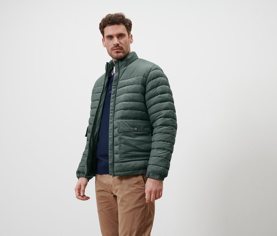 Mann trägt grüne Steppjacke.