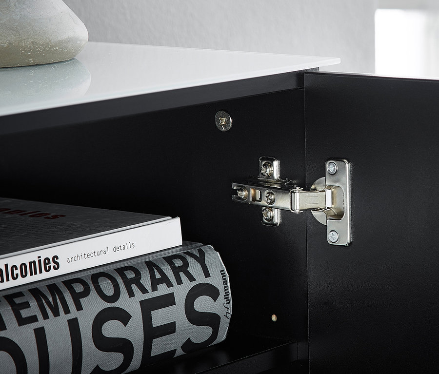 Detailansicht einer geöffneten Tür des schwarzen Highboards »Ideeus« mit Büchern im Inneren.