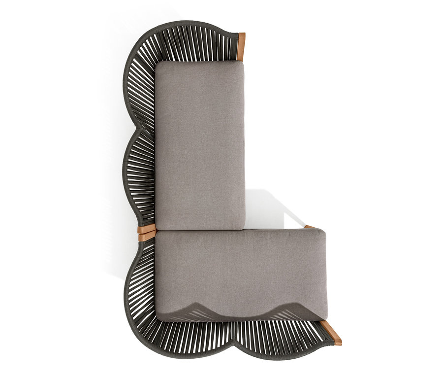 Draufsicht einer Lounge-Ecke mit Textilgeflecht und grauen Kissen.