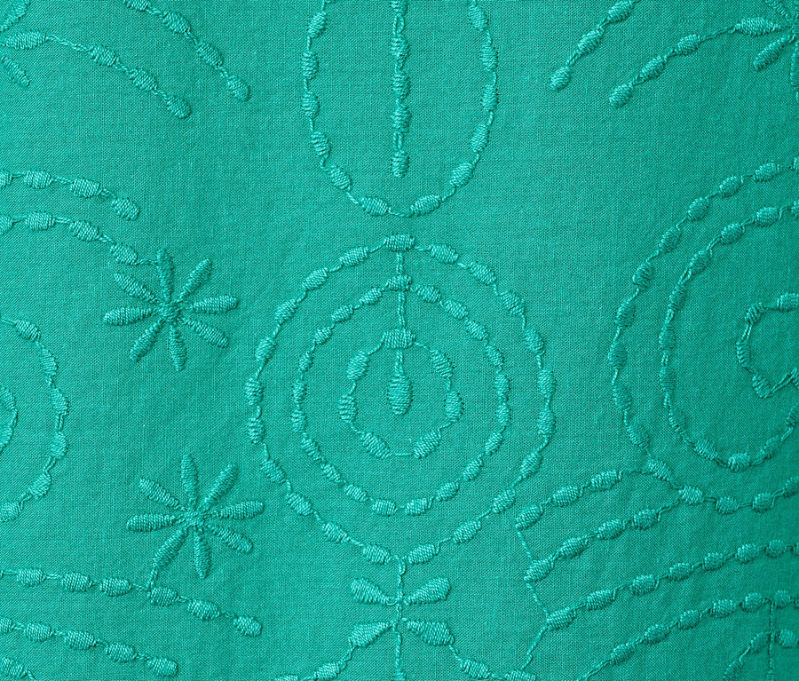 Detail einer grünen Bluse mit Stickerei.