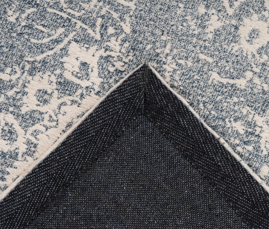 Detailaufnahme eines blau-weißen klassischen Kayoom Iglesia 400 Jacquard-Teppichs.