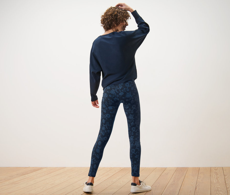 Frau von hinten trägt blaue bedruckte Leggings.