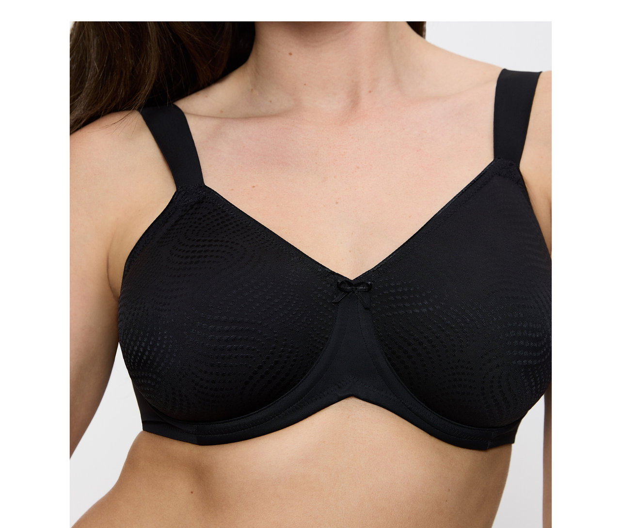 Frau trägt einen schwarzen Triumph Essential »Minimizer W X« BH mit strukturierten Cups und einer kleinen Schleife.